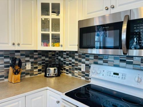 a kitchen with white cabinets and a stove top oven at Beach Ya There in Holden Beach