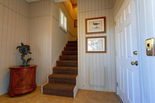 a hallway with a staircase in a home at The Seventh Day in Holden Beach