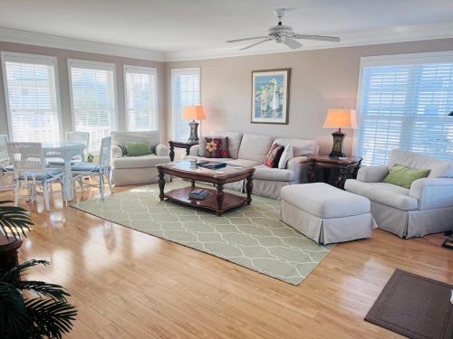 a living room with a couch and a table at Victoria in Holden Beach