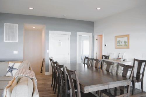 a dining room with a wooden table and chairs at Nautilus Home in Holden Beach