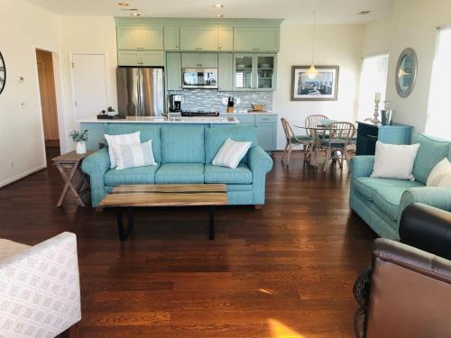 a living room with a blue couch and a kitchen at Holden Hideaway condo in Supply