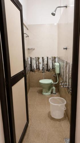 a bathroom with a toilet and a sink and a shower at Happy Mates Forest Villa in Pondicherry