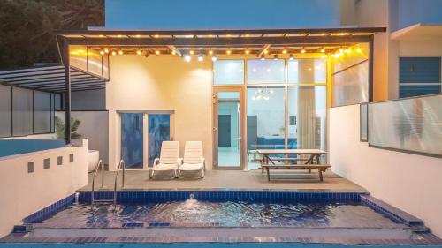 a house with a swimming pool with a table and chairs at yeongdeok chaeumneul poolvilla in Yŏngdŏk