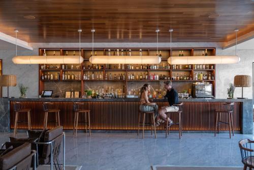 a man and a woman sitting at a bar at ME by Meliá Cabo - Adults Only in Cabo San Lucas