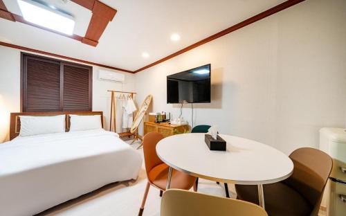 a bedroom with a bed and a table and chairs at Romance Hotel in Seoul
