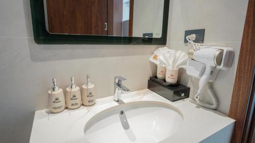 a bathroom sink with a hair dryer and a phone at Pi Hotel Phố cổ Hoa Lư in Kỳ Vĩ