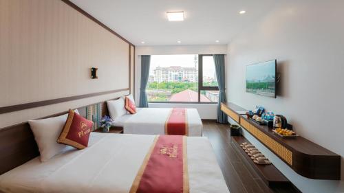 a hotel room with two beds and a window at Pi Hotel Phố cổ Hoa Lư in Kỳ Vĩ