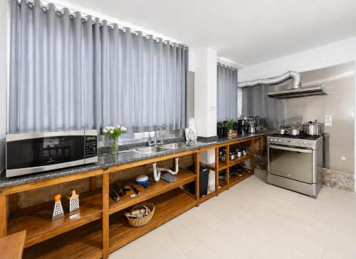 a kitchen with a counter with a sink and a microwave at Riverside Estate with Jacuzzi 9 Bedroom 7 Bath in Baños