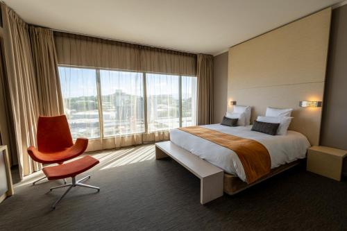 a hotel room with a bed and a large window at Hôtel du Centre Appart hôtel Business avec Parking Gratuit à Nouméa in Noumea