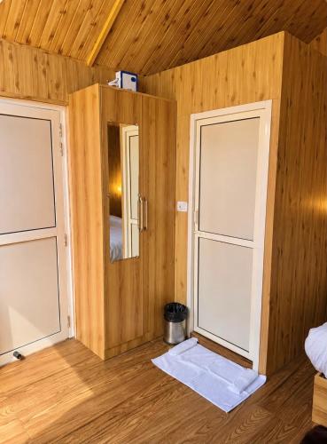 two doors in a room with wooden walls at Treehouse by the lake in Bhīm Tāl