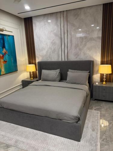 a bedroom with a large bed with two lamps at Emanzara in Islamabad