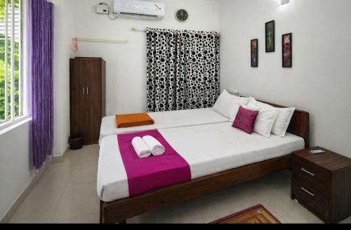 a bedroom with a bed with two towels on it at LA CASA THE HOMESTAY in Trivandrum