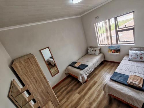 a bedroom with two beds and a window at Princess Vlei Lodge in Grassy Park