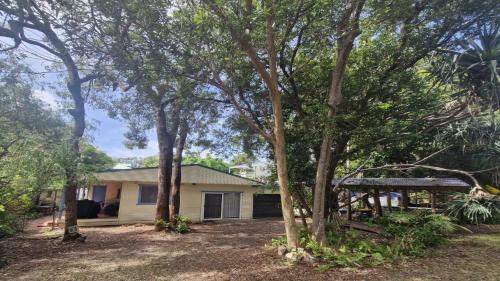 a house with trees in front of it at Beachside Bungalow in Minnie Water