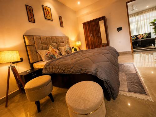 a bedroom with a large bed and two stools at Cozy and Tranquil nest with wifi and homely care in Greater Noida