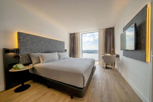a bedroom with a large bed and a large window at INNSiDE by Meliá Liverpool in Liverpool