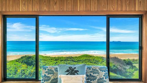 a room with a view of the ocean through a window at Kokomo in Wooli