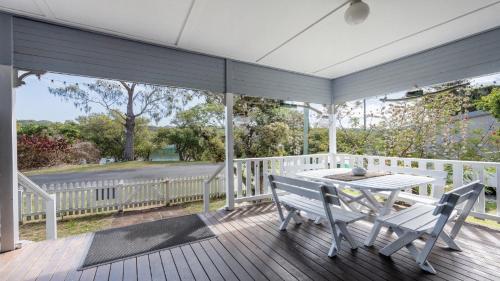 a porch with a table and chairs on a deck at Wooli House in Wooli