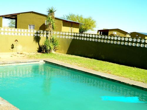 a swimming pool in a yard next to a fence at Vastrap Guest Farm in Grünau