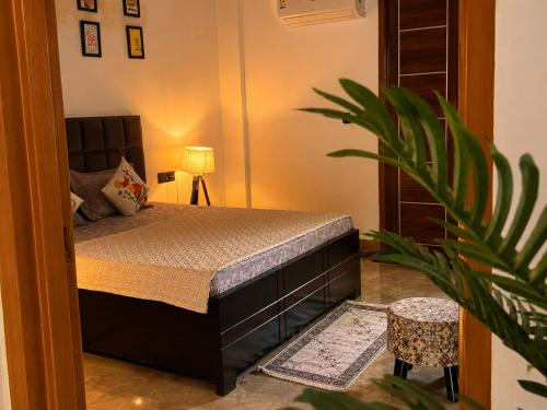a bedroom with a bed and a potted plant at Cozy and Tranquil nest with wifi and homely care in Greater Noida