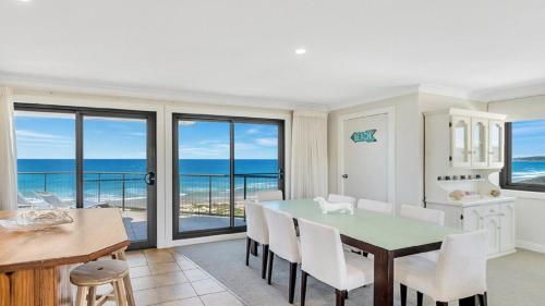 a dining room with a table and views of the ocean at The Peninsula Wooli in Wooli