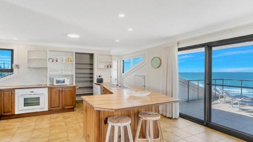 a kitchen with a table and chairs and a balcony at The Peninsula Wooli in Wooli