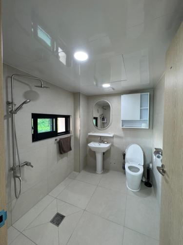 a bathroom with a toilet and a sink at Lakestone&Hotel Sokcho in Sokcho