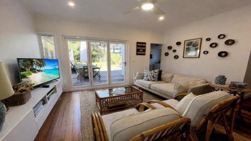 a living room with a couch and a tv at Sea Legs in Wooli