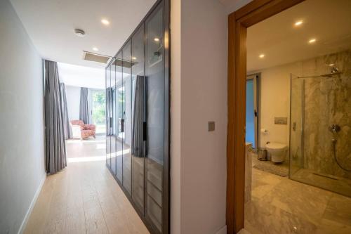 a hallway with a glass door leading to a bathroom at Villa Matie Bodrum Views in Bodrum City