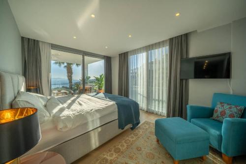 a bedroom with a bed and a blue chair at Villa Matie Bodrum Views in Bodrum City