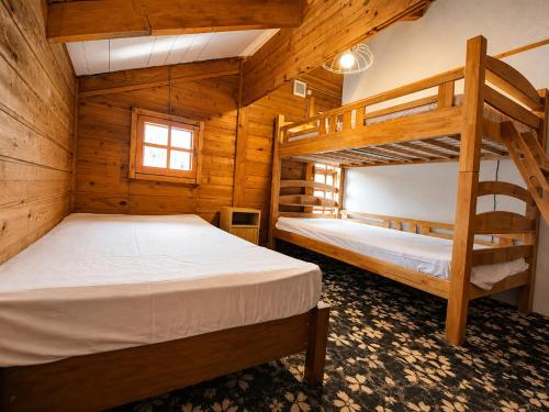 a bedroom with two bunk beds in a cabin at Maple House Backpackers in Iiyama