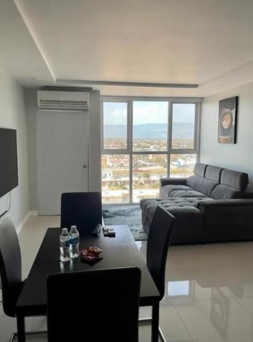 a living room with a couch and a table with chairs at The Grand suite in Portmore