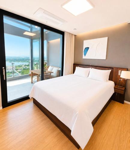 a bedroom with a large bed and a large window at 플럼바고올스위트34 in Chosan-ni