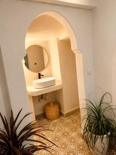 a bathroom with a sink and a mirror at Dar la famille Marrakech in Marrakesh