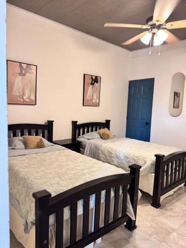a bedroom with two beds and a ceiling fan at Casa Dulce in Estelí
