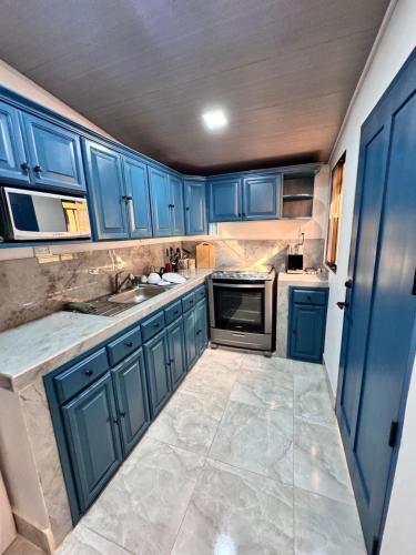 a kitchen with blue cabinets and a sink at Casa Dulce in Estelí