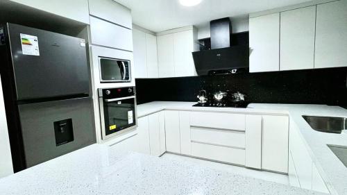 a kitchen with white cabinets and a black appliance at Morada del Huascarán in Mancos
