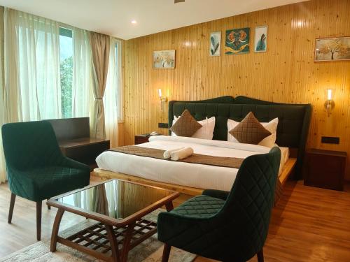 a bedroom with a bed and two chairs and a table at Cottages & Cafe in Dogadda
