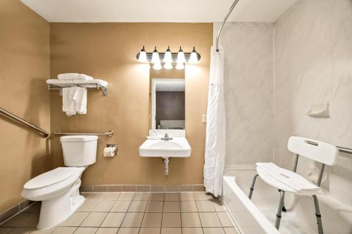 a bathroom with a toilet and a sink at Days Inn & Suites by Wyndham Logan in Logan