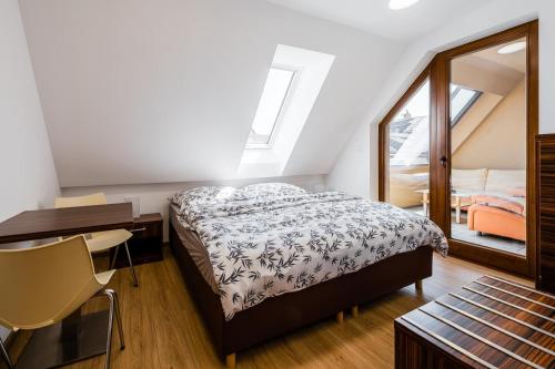 a bedroom with a bed and a desk and a window at Jarkova panorama view in Prešov