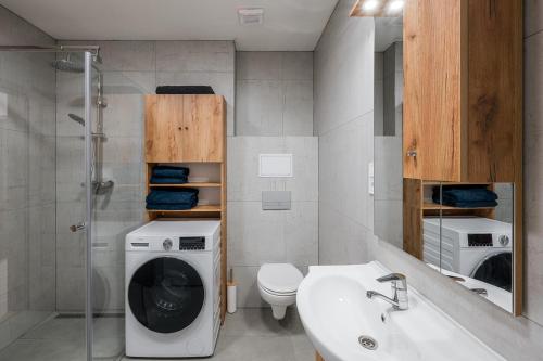 a bathroom with a washing machine and a sink at Jarkova panorama view in Prešov