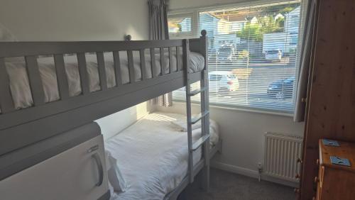 a bedroom with two bunk beds and a window at High Tide in Braunton