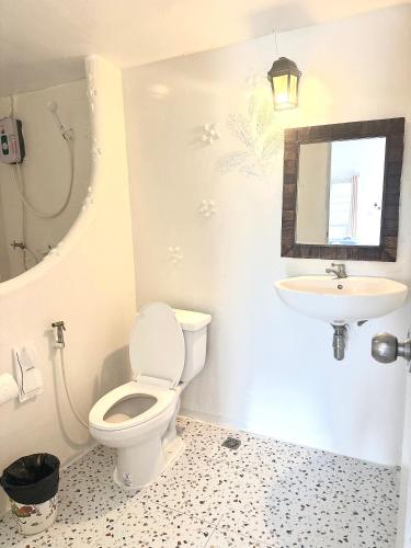 a bathroom with a toilet and a sink at Baan Suan Rojjana in Muak Lek District