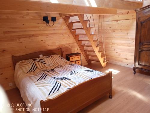 a bed in a wooden room with a staircase at la bergerie in Cronce