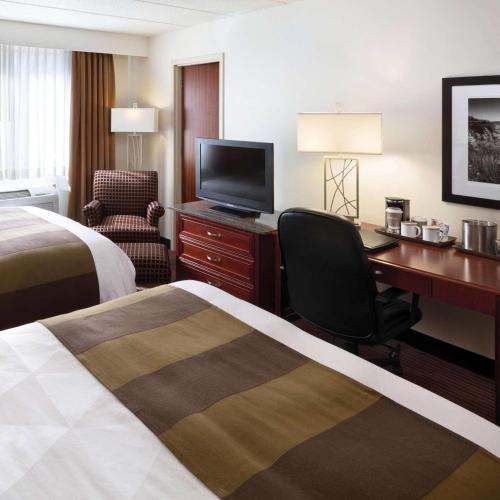 ein Hotelzimmer mit zwei Betten und einem Schreibtisch mit Computer in der Unterkunft Radisson Hotel Bismarck in Bismarck