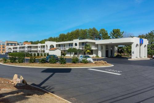 un estacionamiento frente a un gran edificio en Motel 6-Newnan, GA, en Newnan