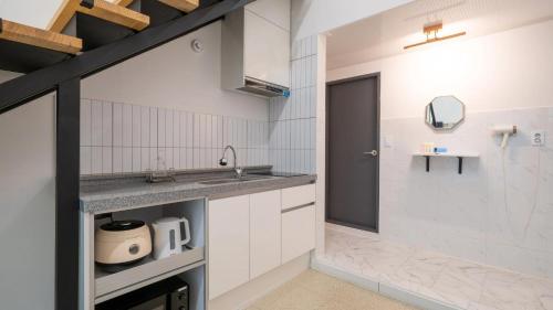a kitchen with white cabinets and a sink at GaPyeong Yeoldudal Spapension&Camping in Gapyeong
