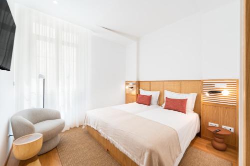 a bedroom with a white bed and a chair at Alluz Nazare - Boutique Chalet By The Sea in Nazaré