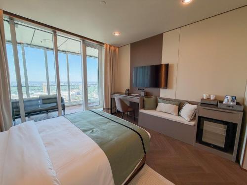 a hotel room with a bed and a couch and a desk at Boutique Hotel 19D in Almaty