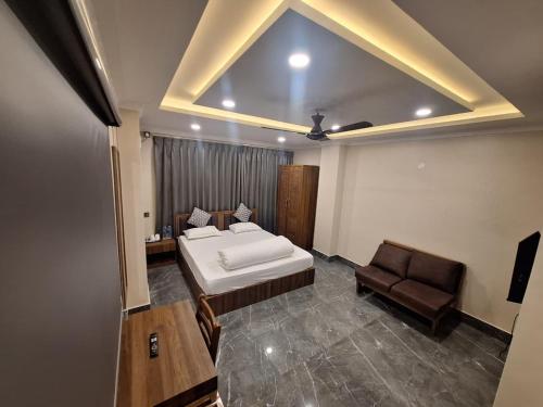 a bedroom with a bed and a couch and a chair at Sun Hill Homestay in Siliguri